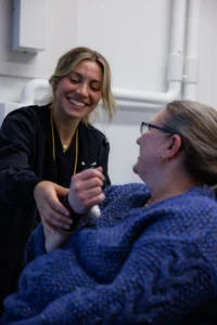 McKenzie Dental Center’s dental assistant taking a patient’s blood pressure, while holding it in place.